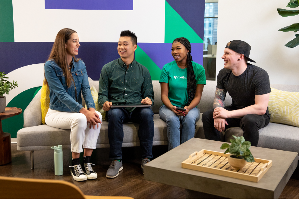Four racially and gender-diverse Sprout employees engaging in friendly dialogue.